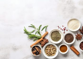 Traditional Chinese herbal medicine in white porcelain bowls on a marble background viewed from above Copy space image Place for adding text or design